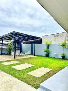 a pavilion with a table and benches in a yard at Jumira Staycation in Tagum