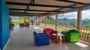 a balcony with chairs and a table and mountains at Mountain View Finca Campestre in Manizales