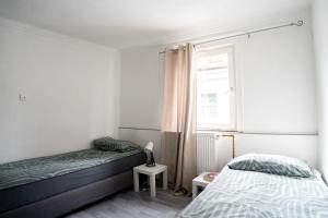 a bedroom with two beds and a window at KiRoom Willsbach 2 und 3 in Obersulm