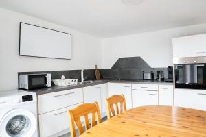 a kitchen with a table and chairs and a microwave at KiRoom Willsbach 2 und 3 in Obersulm