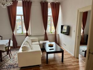 ein Wohnzimmer mit einem weißen Sofa und einem Tisch in der Unterkunft Maxplatz in Rehau
