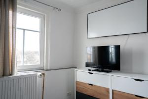 a living room with a flat screen tv on a wall at KiRoom Willsbach 2 und 3 in Obersulm