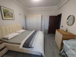a bedroom with a bed and a dresser and a mirror at Matilda apartment in Fier