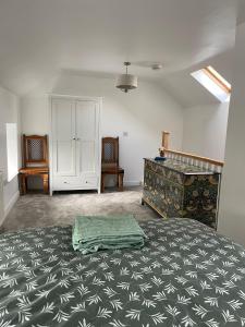 a bedroom with a large bed and a dresser at Ty capel cottage in Mold
