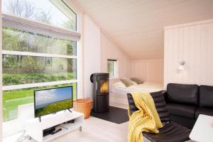 a living room with a couch and a tv and a window at Resort 2 Sea Lodge C 51 in Großenbrode