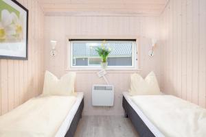 two beds in a small room with a window at Resort 2 Sea Lodge C 51 in Großenbrode