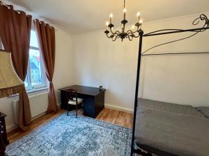 ein Schlafzimmer mit Bett, Schreibtisch und Kronleuchter in der Unterkunft Maxplatz in Rehau