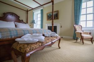 a bedroom with a large bed with towels on a bench at Islay House in Bridgend