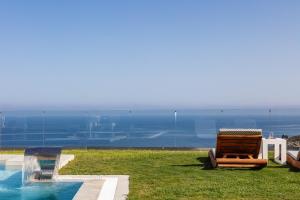 a chair sitting on the grass next to a swimming pool at Villa Ligaria Pinnacle in Ligaria