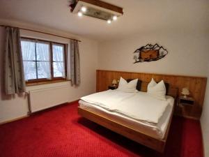 a bedroom with a bed with white sheets and a window at Gasthaus - Pension - Café Dörfl in Kiefersfelden