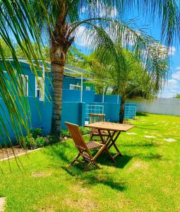 a picnic table and a palm tree next to a blue building at Alldays Sunset Lodge Wilde Street in Alldays
