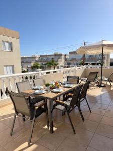 a wooden table and chairs on a balcony at AquaSol Suite Modern 2BR with Shared Pool in Protaras