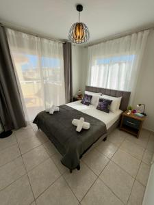a bedroom with a large bed and a large window at AquaSol Suite Modern 2BR with Shared Pool in Protaras +32 photos