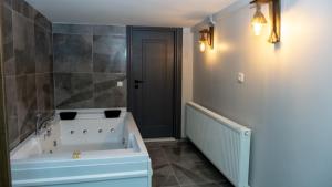 a bathroom with a white tub and a gray wall at Lizbonia Suit Otel in Istanbul