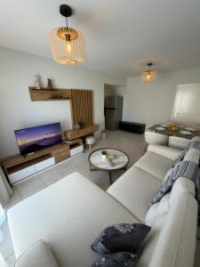 a living room with a couch and a tv at AquaSol Suite Modern 2BR with Shared Pool in Protaras