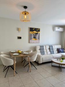 a living room with a couch and a table at AquaSol Suite Modern 2BR with Shared Pool in Protaras