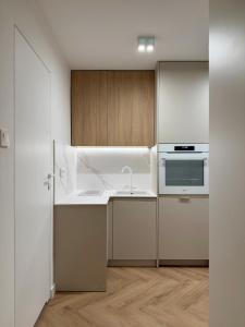a white kitchen with a sink and a microwave at Apartament pod Ratuszem - Kluczbork in Kluczbork +7 photos