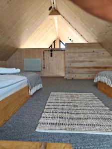 a attic room with two beds and a rug at Domek Fika in Laskowa
