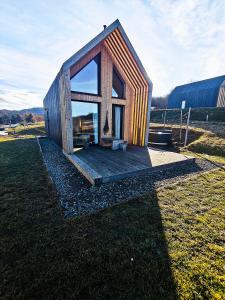 a small wooden house with a large window at Domek Fika in Laskowa