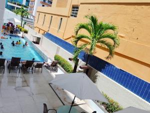an overhead view of a swimming pool with an umbrella at Ocean Flat Tambaú in João Pessoa +30 photos