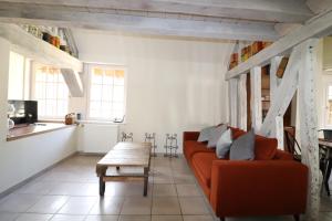 a living room with an orange couch and a table at Duplex Sainte Trinité - Troyes Centre Historique in Troyes