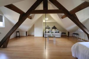 a attic bedroom with a white couch and wooden beams at Duplex Sainte Trinité - Troyes Centre Historique in Troyes