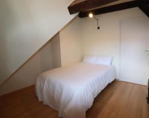 a white bed in a room with a staircase at Duplex Sainte Trinité - Troyes Centre Historique in Troyes +1 photo
