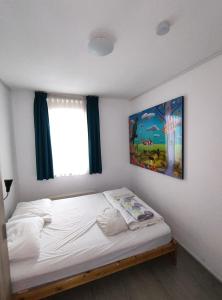 a bedroom with a bed with a painting on the wall at Quiet spacious room in Amsterdam