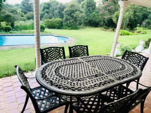 a table and chairs on a patio with a pool at Briar & Bloom2 in Hilton