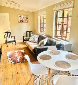 a living room with a couch and a table and chairs at Briar & Bloom2 in Hilton