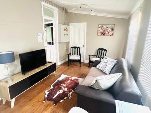 a living room with a couch and a flat screen tv at Briar & Bloom2 in Hilton