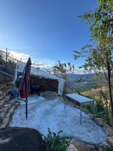 a patio with a table and a bench on a hill at Sen Đá Home 2 in Da Lat +5 photos