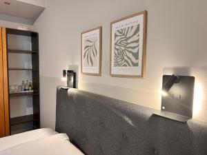 a bedroom with a bed and two pictures on the wall at Hotel Villa Solln - free parking in Munich