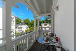 a porch with a table and chairs on a balcony at Villa Eden II in Binz