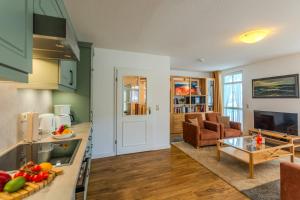 a kitchen and a living room with a table at Villa Eden II in Binz +9 photos
