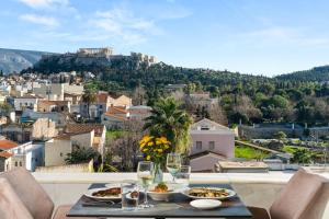 a table with two plates of food and wine glasses at Athenaeum Eridanus Luxury Hotel in Athens