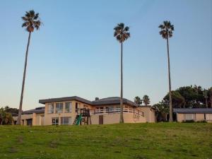 a house with two palm trees and a playground at THE HAVEN HOTEL in Mpume