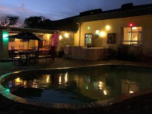 a swimming pool in front of a house at night at THE HAVEN HOTEL in Mpume
