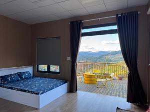 a bedroom with a bed and a balcony with a view at Sen Đá Home 2 in Da Lat