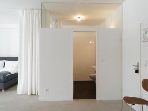 a bedroom with white walls and a bed and a sliding door at KAJO269 FERIENcc WOHNUNGEN IN DER ALTSTADT in Freiburg im Breisgau +107 photos
