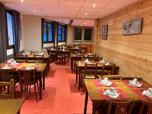 a dining room with wooden tables and chairs at Les Carlines in Vars