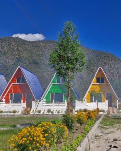 a row of colorful homes with mountains in the background at Lanying Riverview Homestay in Dirang Dzong