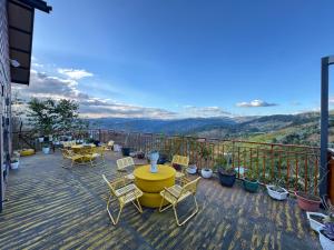 a patio with a yellow table and chairs on a balcony at Sen Đá Home 2 in Da Lat