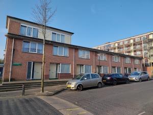 a row of cars parked in front of a brick building at Quiet spacious room in Amsterdam