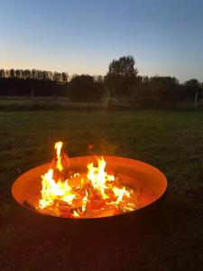 a fire pit in the middle of a field at Cyclodges – Marguerite et Ferdinand in Hotton