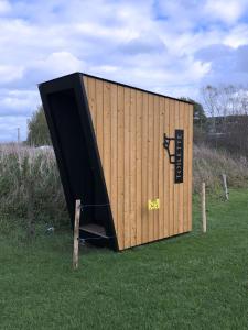 a large wooden container sitting in the grass at Cyclodges – Marguerite et Ferdinand in Hotton