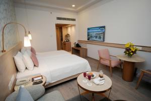 a hotel room with a bed and a table and chairs at Muse Sarovar Portico Nehru Place in New Delhi +43 photos
