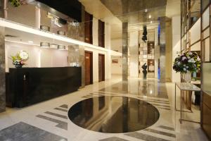 a hallway with a lobby with a person in the distance at Muse Sarovar Portico Nehru Place in New Delhi
