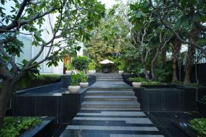 a walkway in a garden with trees and plants at Muse Sarovar Portico Nehru Place in New Delhi