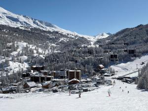 a group of people skiing down a snow covered mountain at Les Carlines in Vars